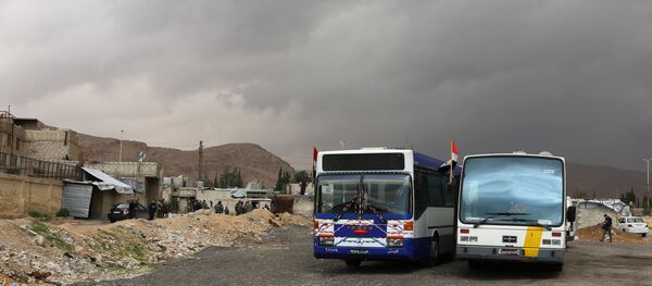 Припадници сиријских владиних снага стоје поред аутобуса на контролном пункту у предграђу Дамаска током операције извлачења скоро 400.000 становника Источне Гуте да напусте ову енклаву Припадници сиријских владиних снага стоје поред аутобуса на контролном пункту у предграђу Дамаска током операције извлачења скоро 400.000 становника Источне Гуте да напусте ову енклаву - Sputnik Србија