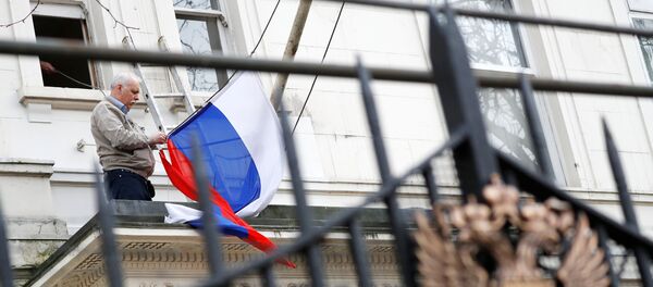 Човек скида заставу Русије са зграде руске дипломатске мисије у Лондону Човек скида заставу Русије са зграде руске дипломатске мисије у Лондону - Sputnik Србија