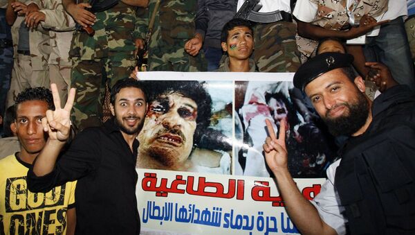 Pobunjenici iz Libije slave pored transparenta sa fotografijom ubijenog Muamera Gadafija. - Sputnik Srbija