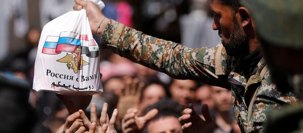 Припадници сиријске војске деле хуманитарну помоћ руских снага цивилима који су напустили Источну Гуту - Sputnik Србија