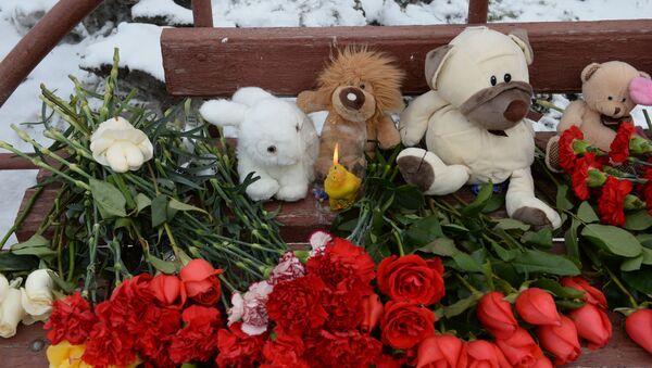 Цветы, свечи и мягкие игрушки возле здания торгового центра «Зимняя вишня» в Кемерово, где произошел пожар - Sputnik Србија