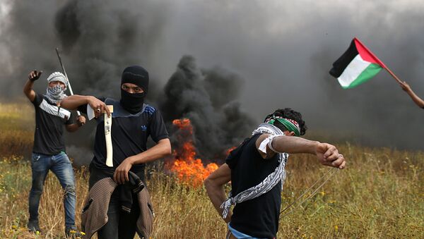 Палестински демонстратор држи секиру током сукоба са израелским трупама у граду Гази 30. марта 2018. - Sputnik Србија