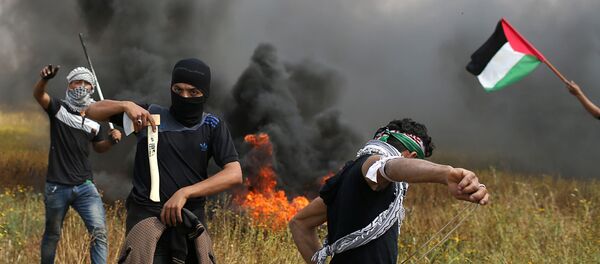 Palestinski demonstrator drži sekiru tokom sukoba sa izraelskim trupama u gradu Gazi 30. marta 2018. - Sputnik Srbija