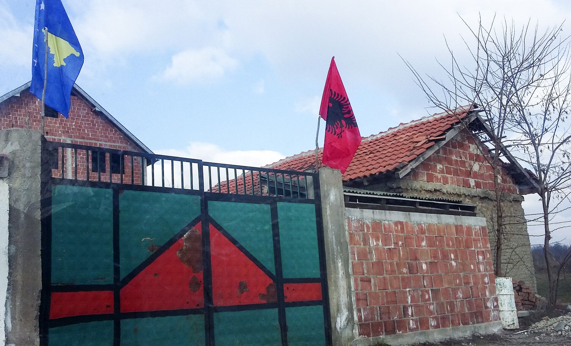 Заставе тзв. Косова и Албаније на капији куће у близини Призрена Заставе тзв. Косова и Албаније на капији куће у близини Призрена - Sputnik Србија, 1920, 07.03.2025