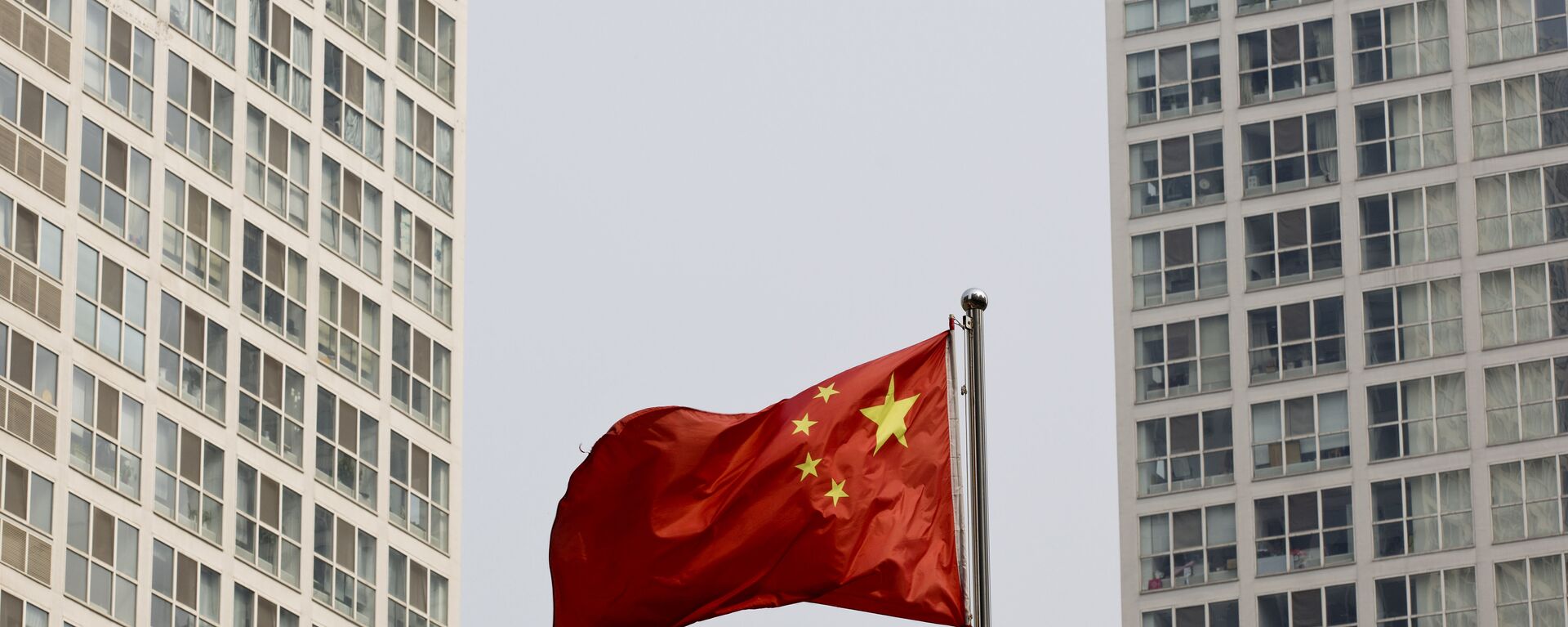 Застава Кине вијори се на ветру између вишеспратница у Пекингу - Sputnik Србија, 1920, 28.10.2021