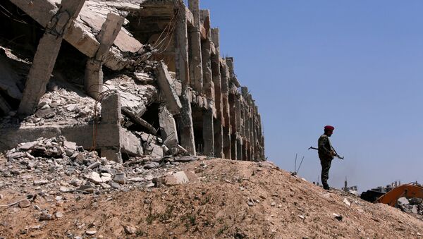 Припадник сиријских владиних снага стоји поред уништене зграде у Џобару, у Источној Гути - Sputnik Србија