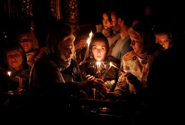 Vernici pale sveće tokom vaskršnje službe u grčkoj pravoslavnoj Crkvi Sveti Đorđe u Istanbulu - Sputnik Srbija
