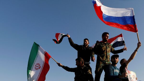 Сиријци машу иранским, руским и сиријским заставама током протеста против ваздушних напада у Дамаску - Sputnik Србија