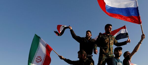 Сиријци машу иранским, руским и сиријским заставама током протеста против ваздушних напада у Дамаску - Sputnik Србија