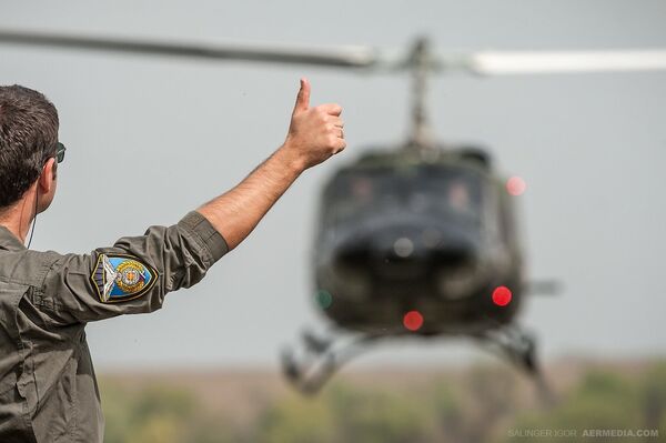 Пилот, у улози официра за навођење, сигнализира колегама у хеликоптеру током вежбе у близини базе САЈ у Батајници. - Sputnik Србија