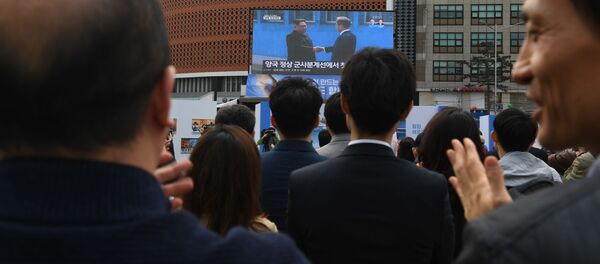 Narod aplaudira dok posmatra prenos uživo rukovanja predsednika Severne i Južne Koreje, Kim Džong Una i Mun Džae Ina Narod aplaudira dok posmatra prenos uživo rukovanja predsednika Severne i Južne Koreje, Kim Džong Una i Mun Džae Ina - Sputnik Srbija