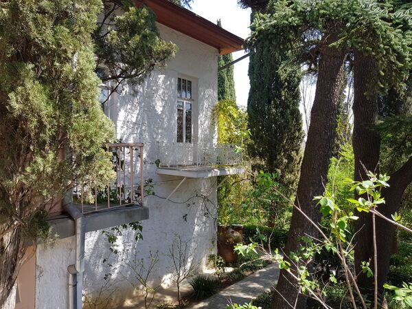 Чеховљева кућа смештена је на узвишици, у прелепом, живописном врту, па се од раскошних крошњи дрвећа готово и не може видети са улице. - Sputnik Србија