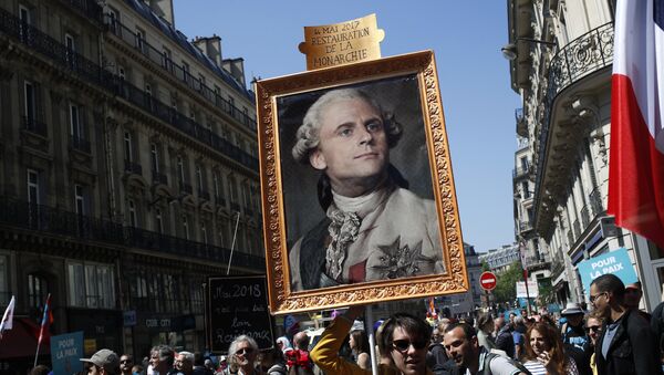 Демонстранти носе слику француског председника Макрона представљеног као Луј XIV на протестима у Паризу - Sputnik Србија