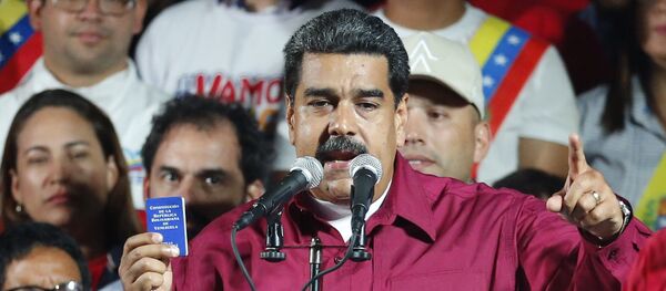 Председник Венецуеле Николас Мадуро држи примерак Устава док се обраћа присталицама у Каракасу Председник Венецуеле Николас Мадуро држи примерак Устава док се обраћа присталицама у Каракасу - Sputnik Србија