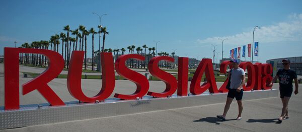 Ljudi prolaze pored instalacije Rusija 2018 u Olimpijskom parku u Sočiju - Sputnik Srbija