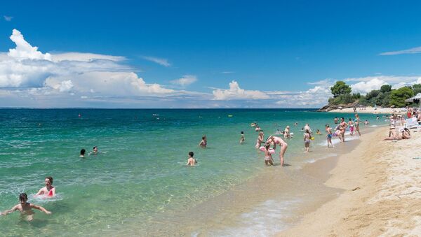 На плажи Лагомандра туристи уживају у топлом мору... - Sputnik Србија