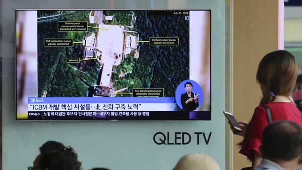Ljudi gledaju satelitske snimke poligona za lansiranje raketa Sohae u Severnoj Koreji na južnokorejskoj televiziji u Seulu - Sputnik Srbija