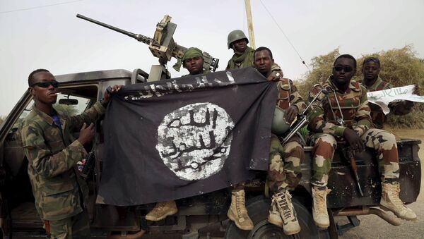 Нигеријски војници држе заставу Боко Харама коју су запленили у недавно обновљеном граду Дамасаку, Нигерија, 18. марта 2015. - Sputnik Србија