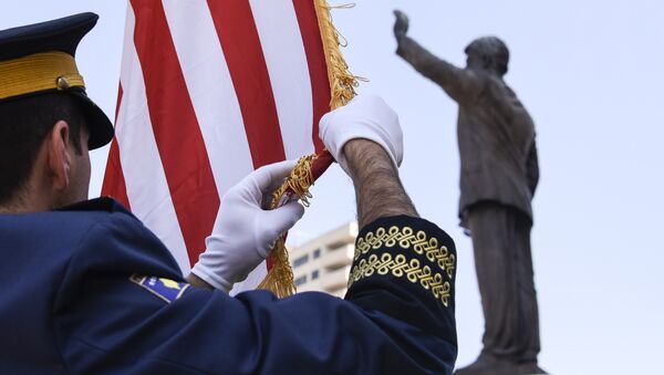 Војник тзв. Косова подиже заставу САД поред споменика Билу Клинтону у Приштини - Sputnik Србија