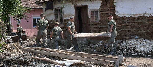 Pripadnici VS u mestu Žagubica pomažu u otkalanjanju štete posle poplava koje su zadesile zaječarki okrug  - Sputnik Srbija