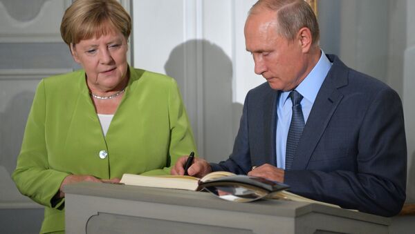 Predsednik Rusije Vladimir Putin ostavlja potpis u knjizi počasnih gostiju za vreme sastanka sa nemačkom kancelarkom Angelom Merkel  u dvorcu Mezeberg - Sputnik Srbija
