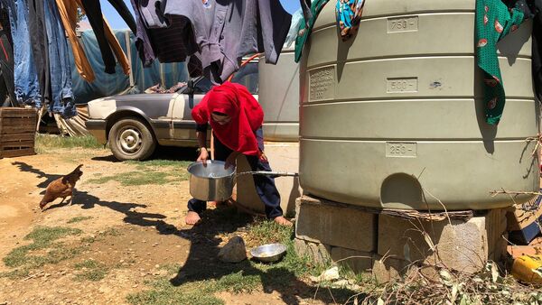Žena sipa vodu u izbegličkom kampu za sirijske izbeglice u Libanu - Sputnik Srbija