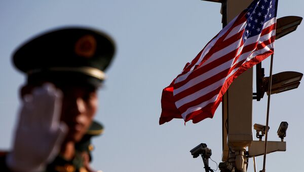 Кинески полицајац стоји испод камера за надзор и застава САД и Кине у близини Забрањеног града у Пекингу - Sputnik Србија