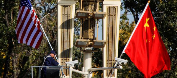 Радник поставља заставе САД и Кине у близини Забрањеног града у Пекингу пре посете америчког председника Доналда Трампа Кини - Sputnik Србија