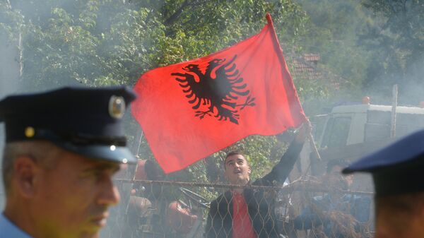 Kosovski Albanac sa zastavom Albanije na blokadi prilazu selu Banje na Kosovu i Metohiji - Sputnik Srbija