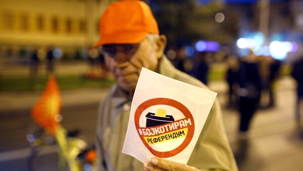Човек са флајером који позива на бојкот референдума у Македонији. - Sputnik Србија