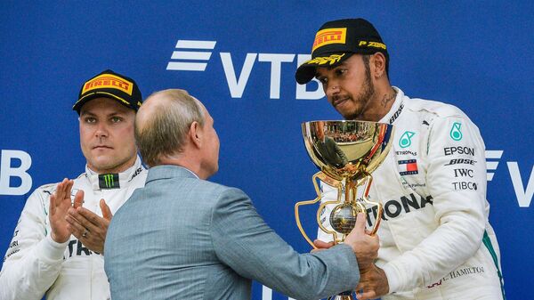 Predsednik Rusije Vladimir Putin uručuje pehar pobedniku trke Formule 1 u Sočiju Luisu Hamiltonu - Sputnik Srbija
