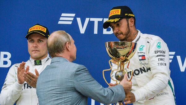 Predsednik Rusije Vladimir Putin uručuje pehar pobedniku trke Formule 1 u Sočiju Luisu Hamiltonu - Sputnik Srbija