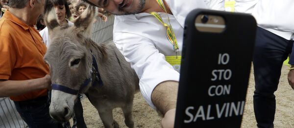 Италијански министар унутрашњих послова и заменик премијера Матео Салвини слика селфи са магарцем у позадини. - Sputnik Србија