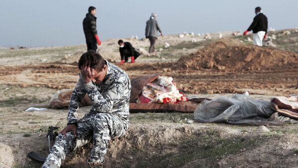 Irački policajac na mestu masovne grobnice u Hamam el Alilu u Iraku - Sputnik Srbija