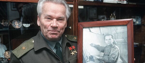 Чувени руски конструктор ватреног оружја и изумитељ чувеног аутомата АК-47, Михаил Калашњиков, са својом фотографијом из времена када је конструисао свој аутомат. Чувени руски конструктор ватреног оружја и изумитељ чувеног аутомата АК-47, Михаил Калашњиков, са својом фотографијом из времена када је конструисао свој аутомат. - Sputnik Србија