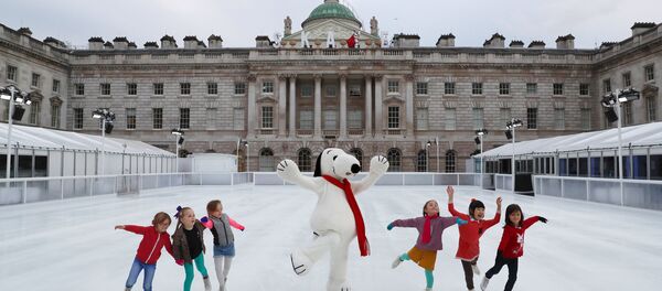 Деца клизају са маскотом Снупија испред Сомерсет хауса у Лондону. - Sputnik Србија