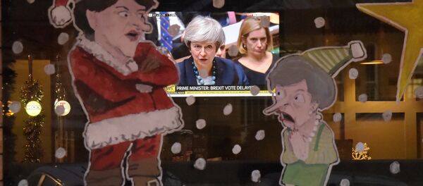 Ljudi u pabu gledaju britansku premijerku Terezu Mej u parlamentu, na TV ekranu, kroz prozor ilustrovan liderkom Unionista Severne Irske Arlen Foster kao Deda Mrazom i Mejove kao božićnim elfom. Lisburn, Severna Irska, 10. decembar 2018. - Sputnik Srbija