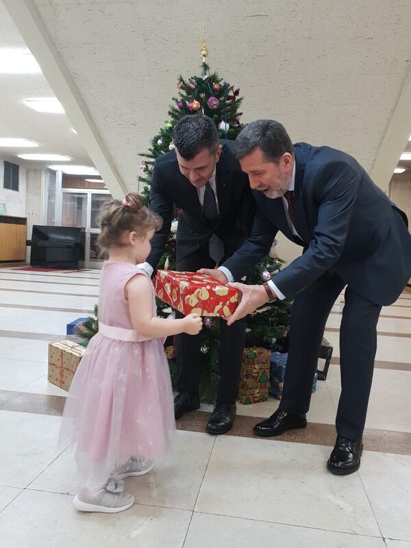 Министар Зоран Ђорђевић и амбасадор Србије у Русији Славенко Терзић деле деци новогодишње пакетиће у амбасади у Москви. - Sputnik Србија