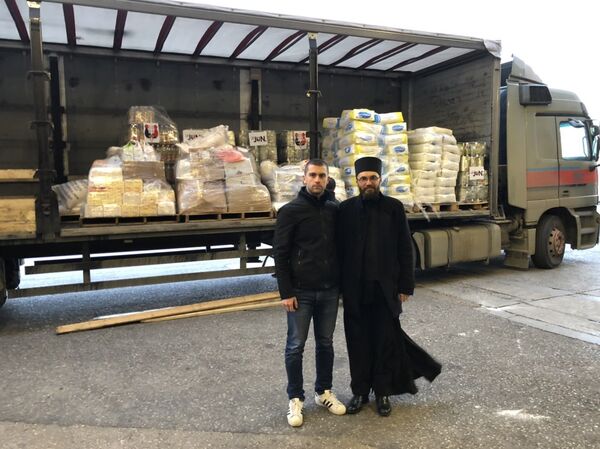 Отац Бранко и волонтер организације 28. Јун Немања Марић испред добротворног фонда Човекољубље митрополије црногорско - приморске у Подгорици. Отац Бранко и волонтер организације 28. Јун Немања Марић испред добротворног фонда Човекољубље митрополије црногорско - приморске у Подгорици. - Sputnik Србија