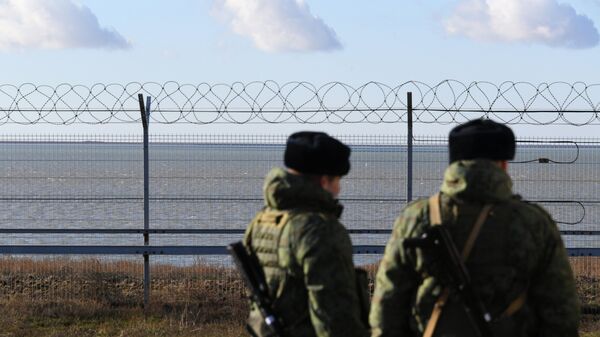 Руски граничари поред ограде подигнуте на Криму на граници са Украјином - Sputnik Србија