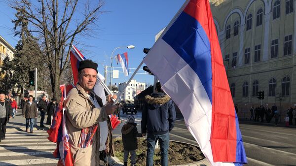 Čovek sa zastavama na ulici Banjaluke očekuje defile - Sputnik Srbija