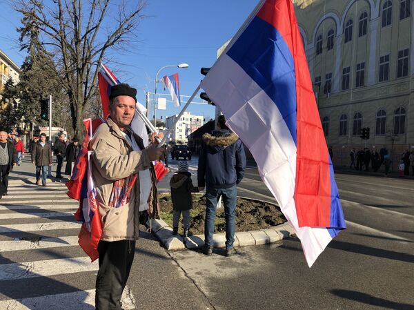 Човек са заставама на улици Бањалуке очекује дефиле - Sputnik Србија