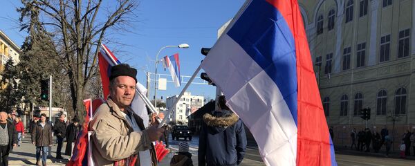 Човек са заставама на улици Бањалуке очекује дефиле - Sputnik Србија
