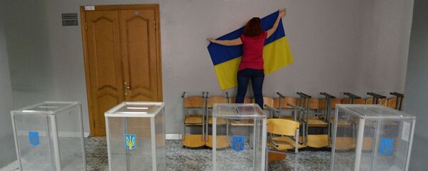 Član izborne komisije postavlja državnu zastavu na biračko mesto za glasanje na predsedničkim izborima u Ukrajini - Sputnik Srbija