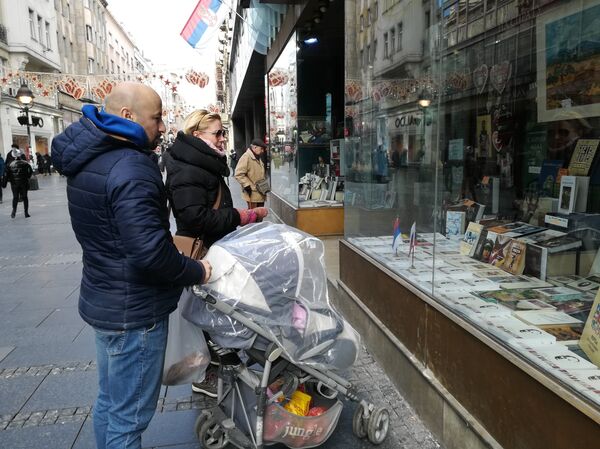 Putin u Knez Mihailovoj privlači pažnju prolaznika, prve mušterije čuvene knjižare jutros su bili Rusi, mladi bračni par sa decom koji turstički obilazi Srbiju. - Sputnik Srbija