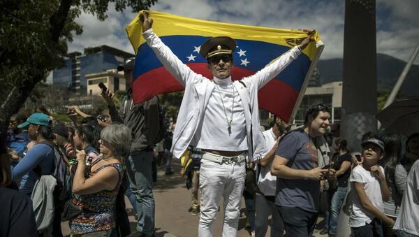 Присталица опозиционог венецуеланског лидера Хуана Гваида носи заставу и руску војну капу на протесту у Каракасу - Sputnik Србија