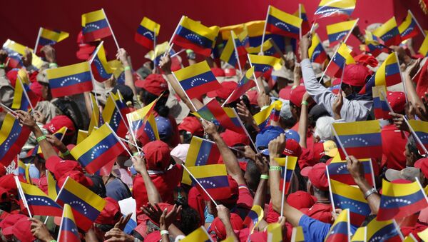 Присталице председника Венецуеле Николаса Мадура машу заставама на митингу у Каракасу - Sputnik Србија