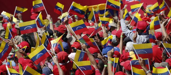 Pristalice predsednika Venecuele Nikolasa Madura mašu zastavama na mitingu u Karakasu Pristalice predsednika Venecuele Nikolasa Madura mašu zastavama na mitingu u Karakasu - Sputnik Srbija