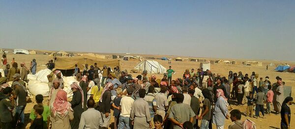 Ljudi se okupljaju da preuzmu osnovne namirnice i drugu pomoć u izbegličkom kampu Rukban na granici Jordana i Sirije - Sputnik Srbija
