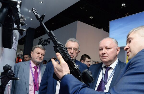 Генеральный директор АО Рособоронэкспорт Александр Михеев (второй справа) осматривает автомат Калашникова 200-й серии на международной выставке вооружений IDEX-2019 в Абу-Даби - Sputnik Србија